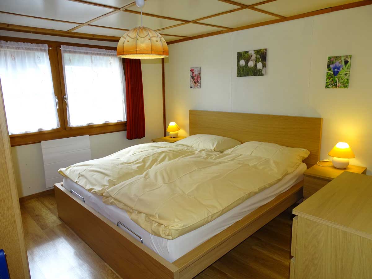 Photo de chambre des parents de l'appartement à louer. Grande chambre lumineuse et chaleureuse, lit double, commodes et grande armoir en bois