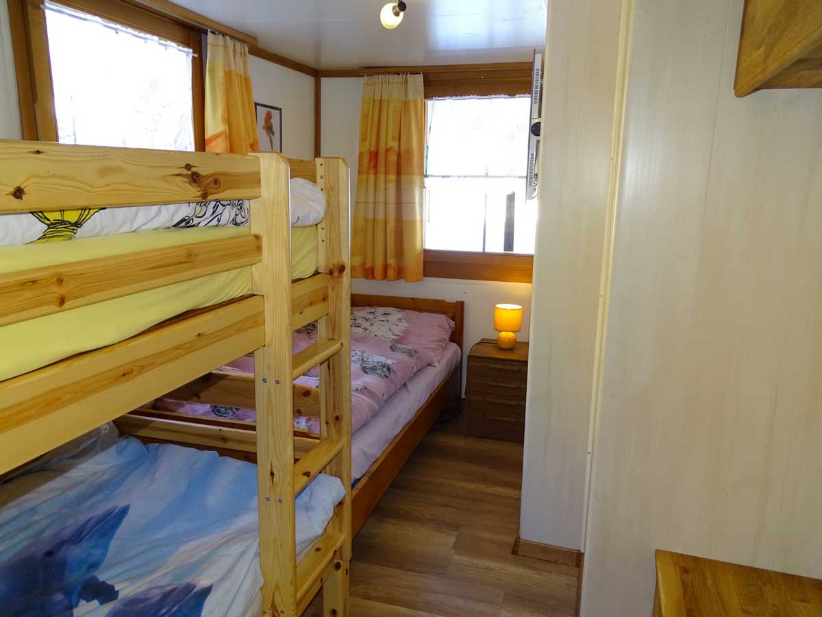 Photo de chambre des enfants de l'appartement à louer. Grande chambre lumineuse et chaleureuse, lit à étage et lit simple, commodes et grande armoir en bois